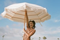 a woman holding an umbrella on the beach